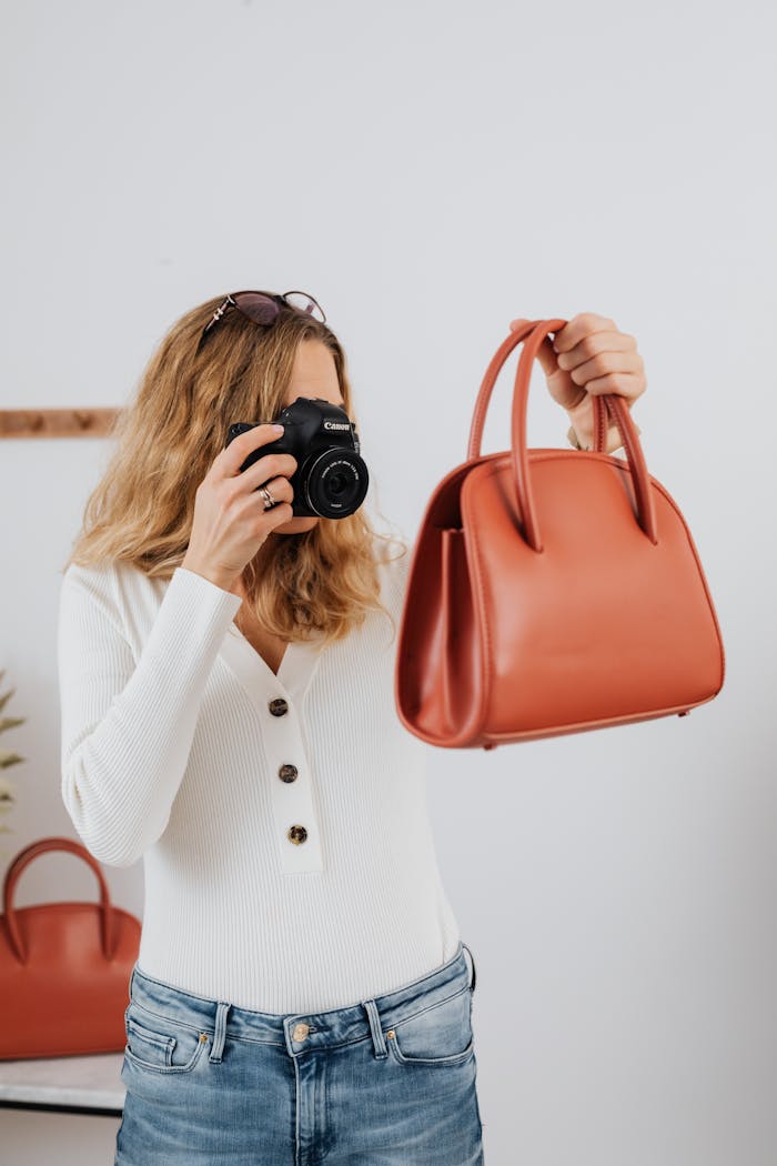 about-us Female photographer capturing a red handbag, showcasing online selling photography techniques.